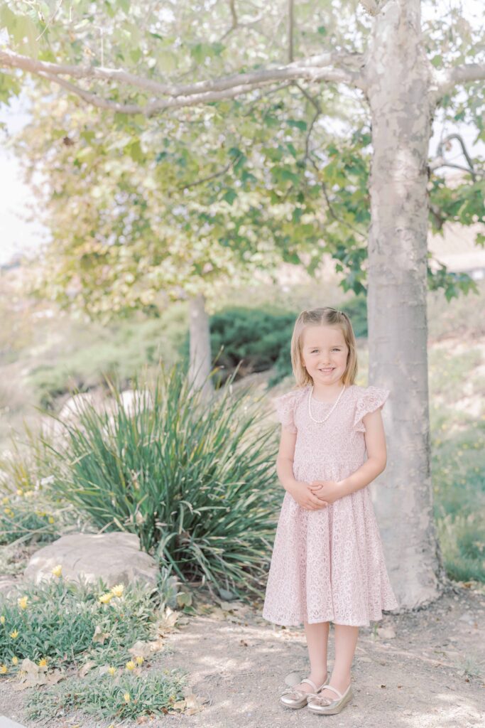 girl wearing pink dress for family photos at san diego park