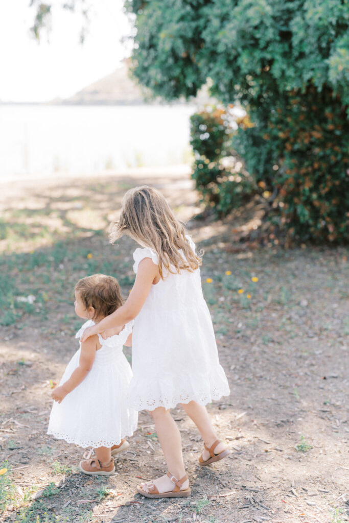 two girls in white dresses walking at lake murray san diego