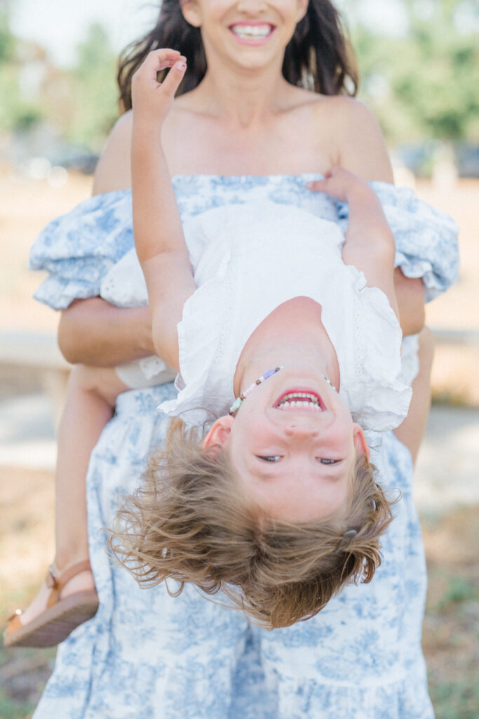 a woman holding a child upside down