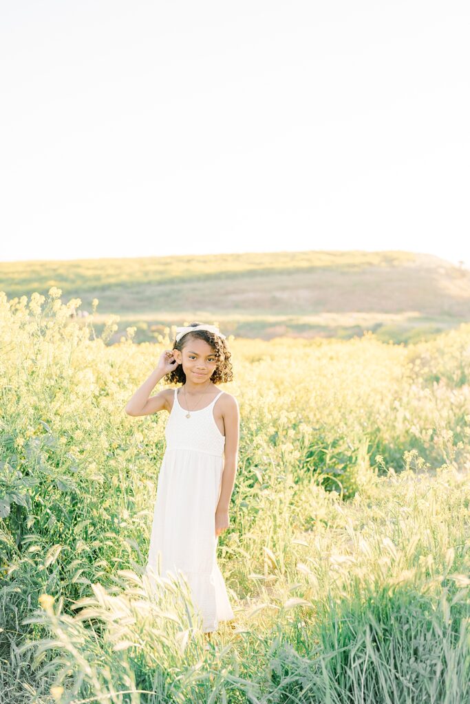 girl wearing white dress and posing at outdoor photoshoot